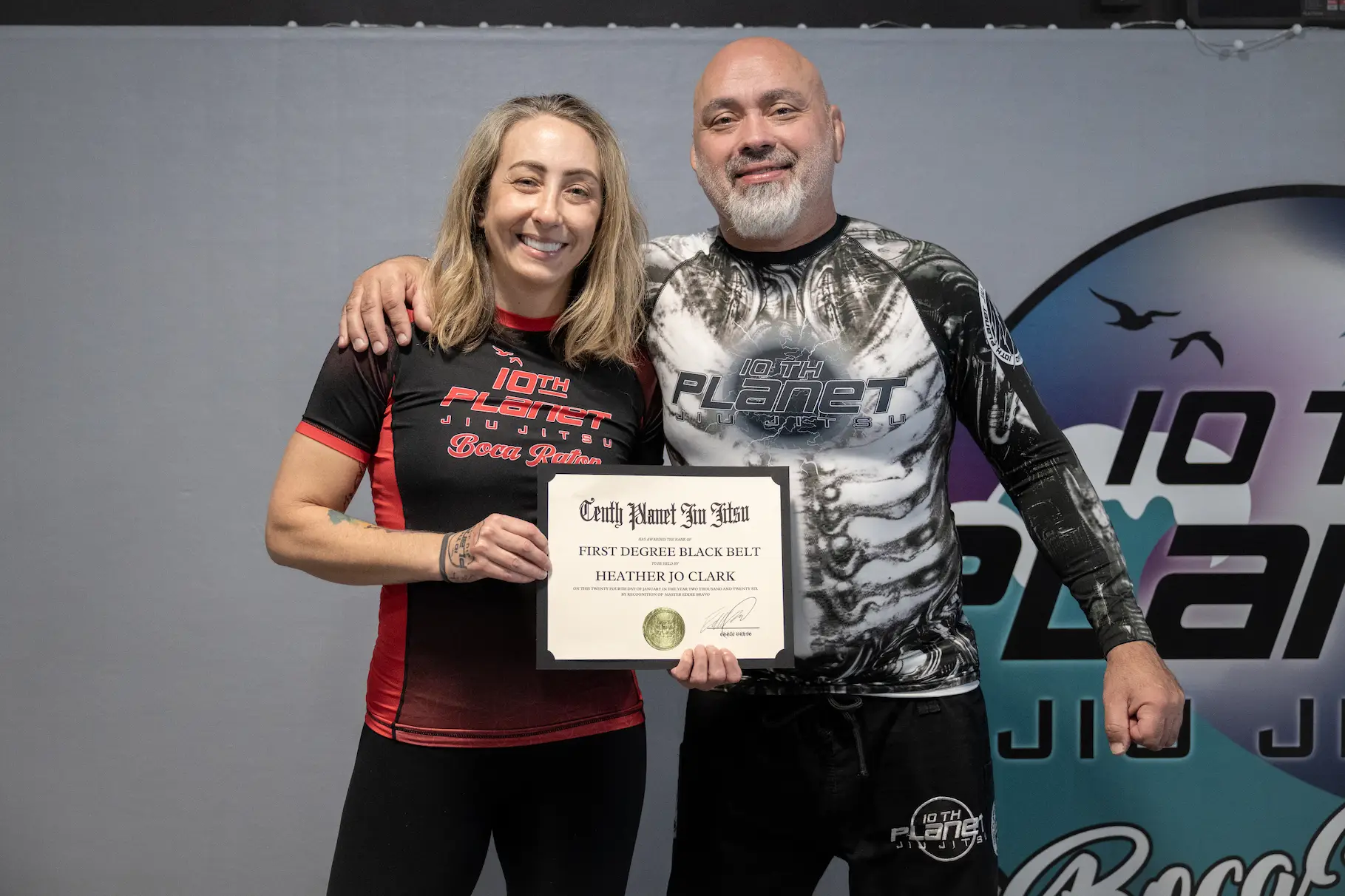 Heather Jo Clark receiving an award from Eddie Bravo
